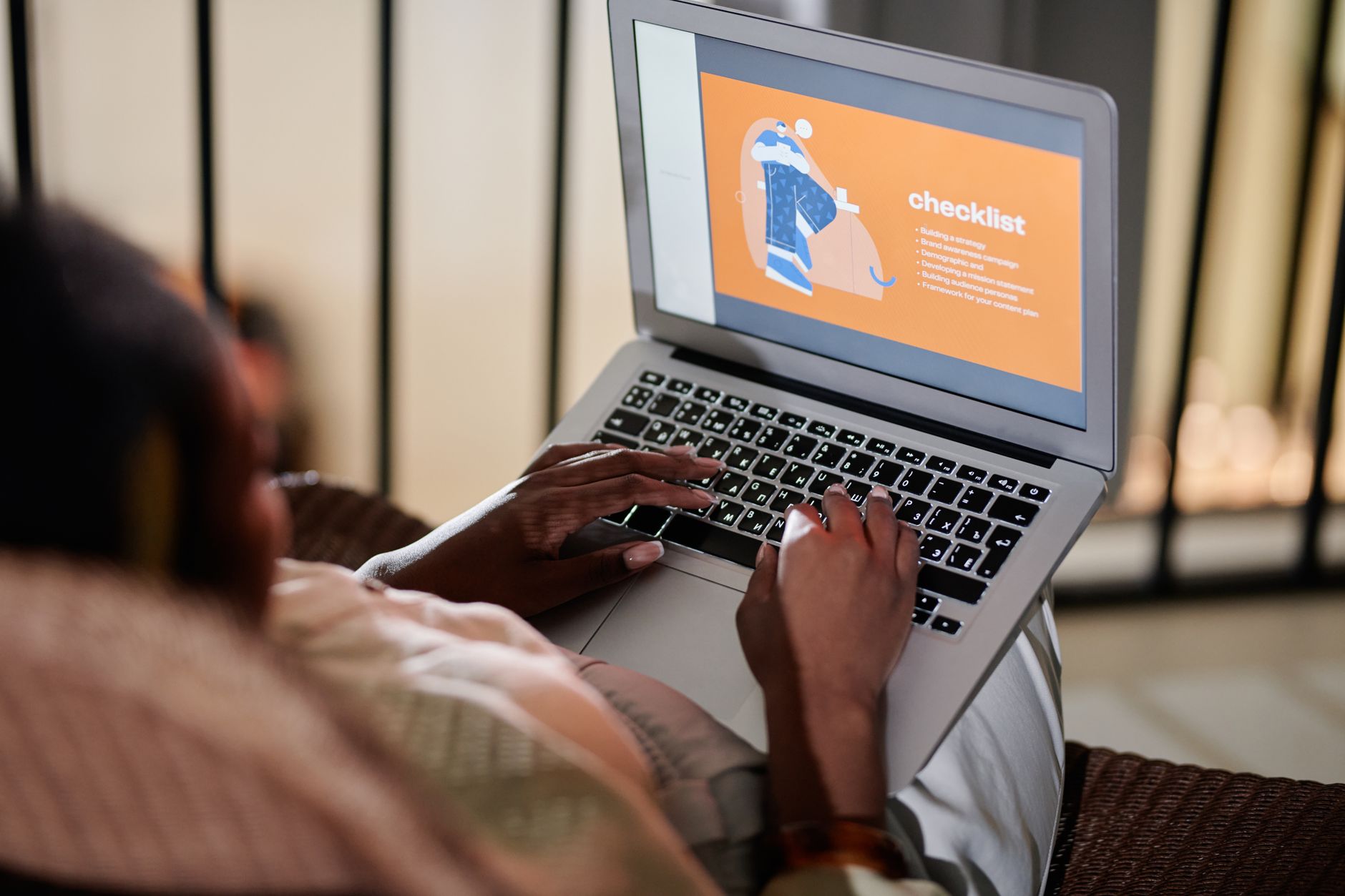 Pessoa conferindo checklist com laptop exibindo avaliações e mapa, em ambiente de pequeno negócio local