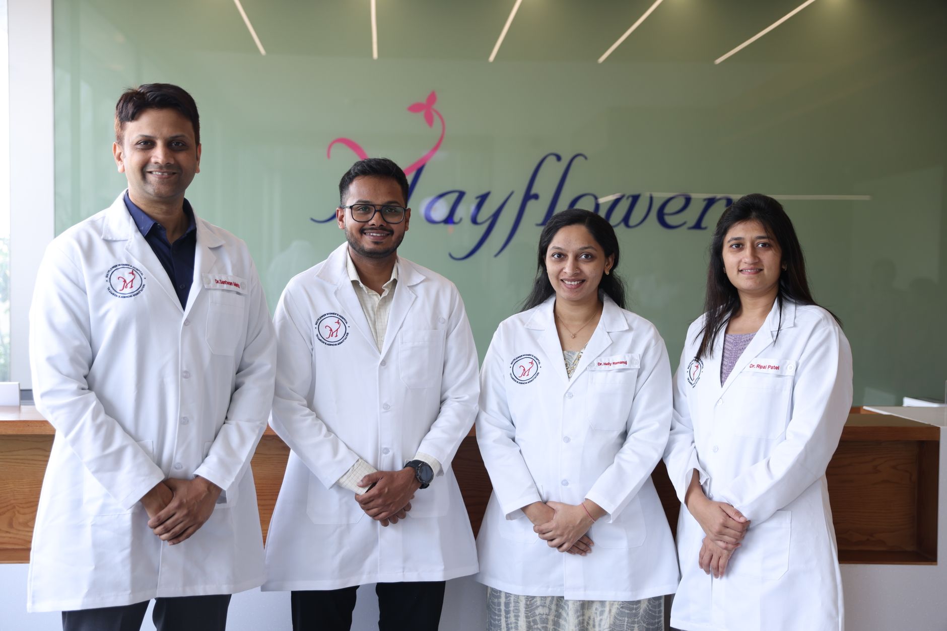 Equipe médica diversa em jalecos profissionais posando juntos no corredor de uma clínica moderna