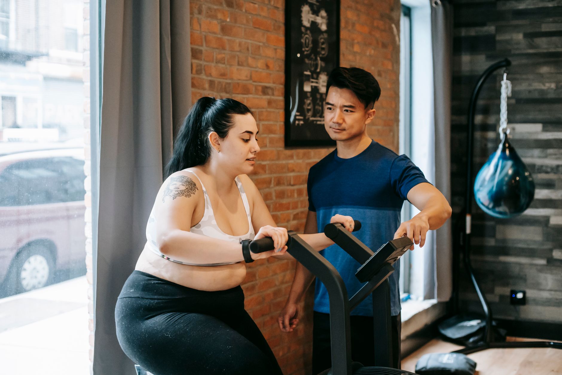 Personal trainer orientando aluno em ambiente de treino profissional