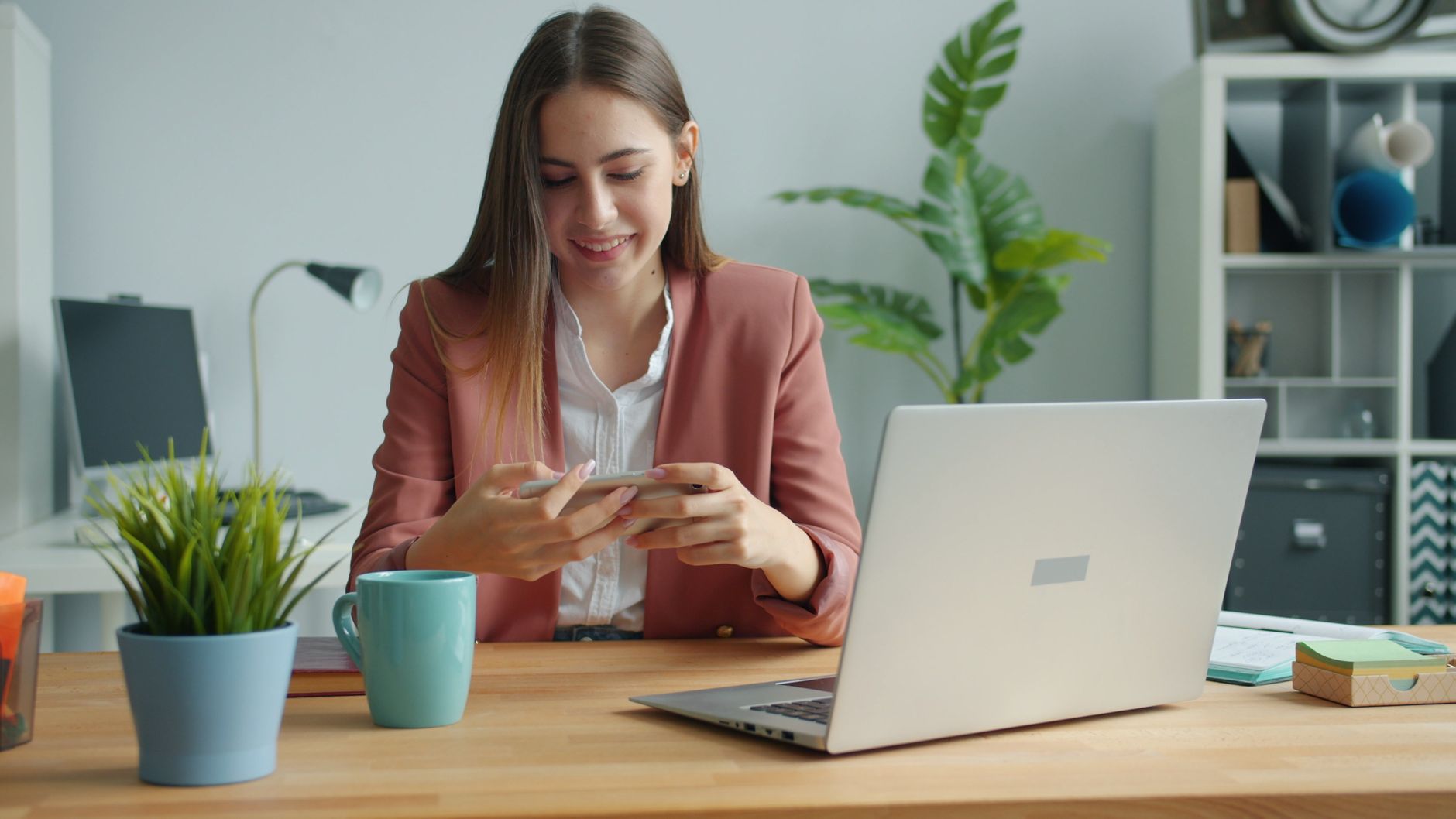 Empreendedor em sua loja local olhando para o laptop e o smartphone, refletindo sobre presença digital