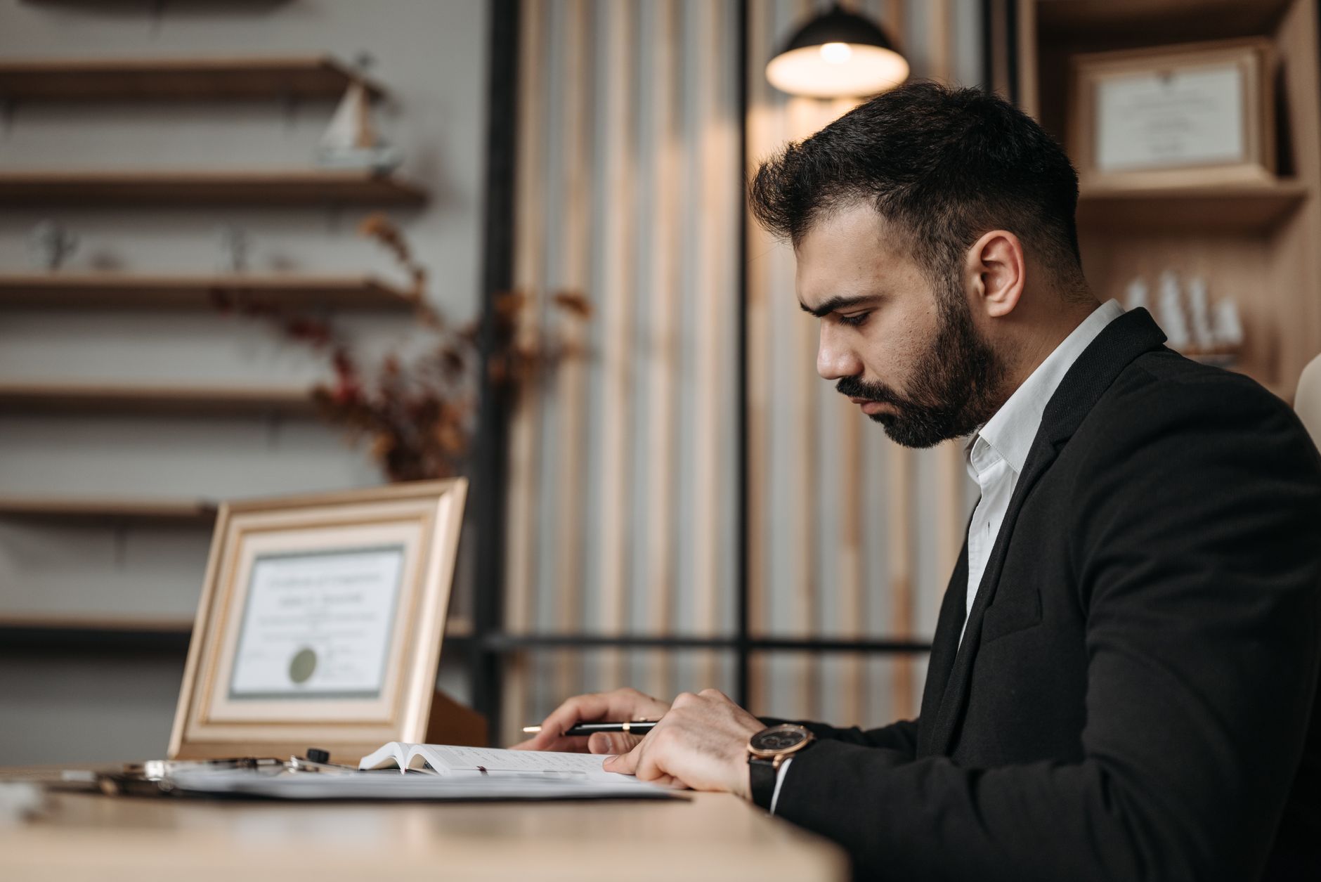 Advogado profissional trabalhando em escritório moderno com laptop e documentos jurídicos, transmitindo confiança e organização