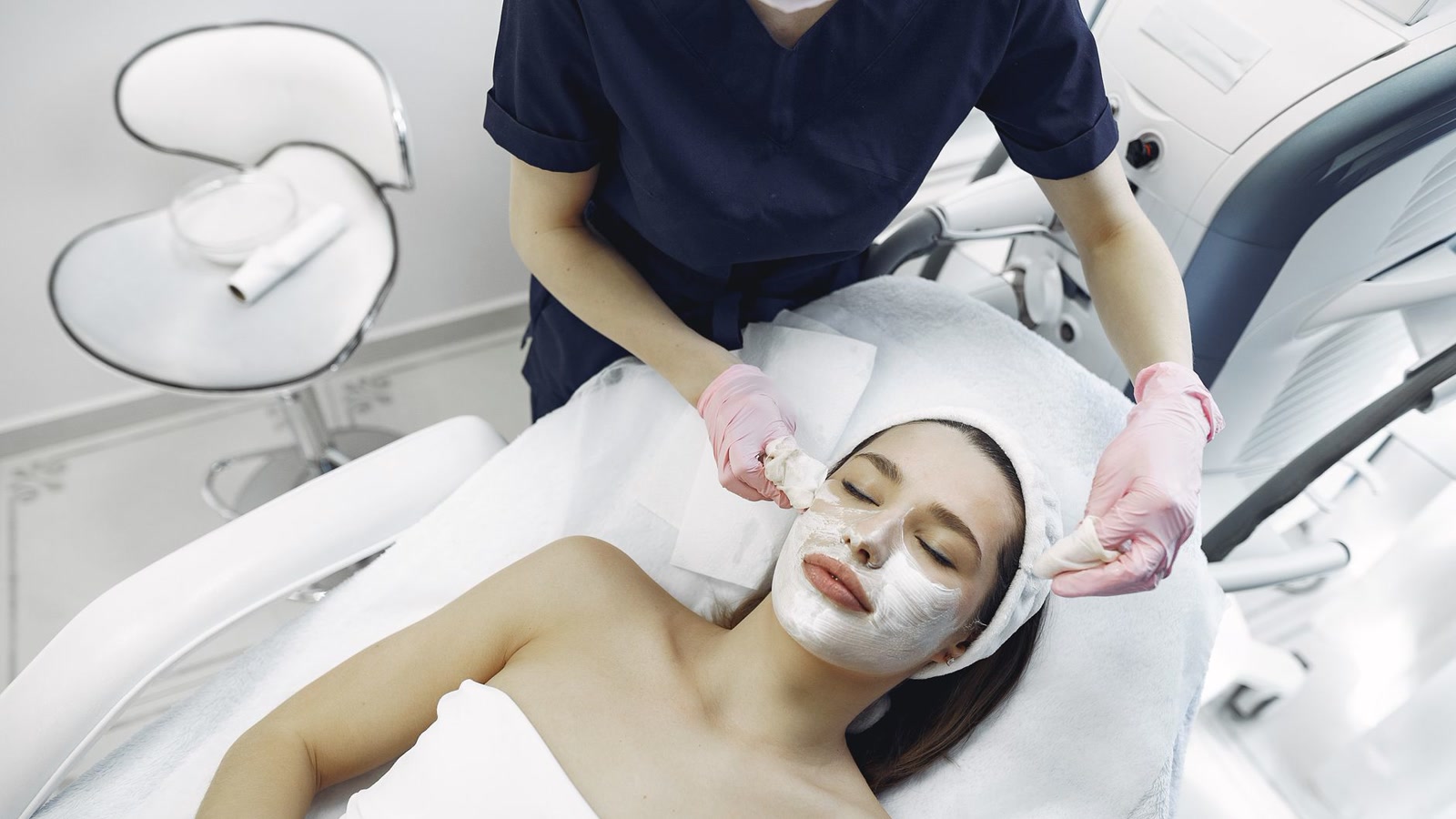 Profissional realizando tratamento facial em clínica de estética