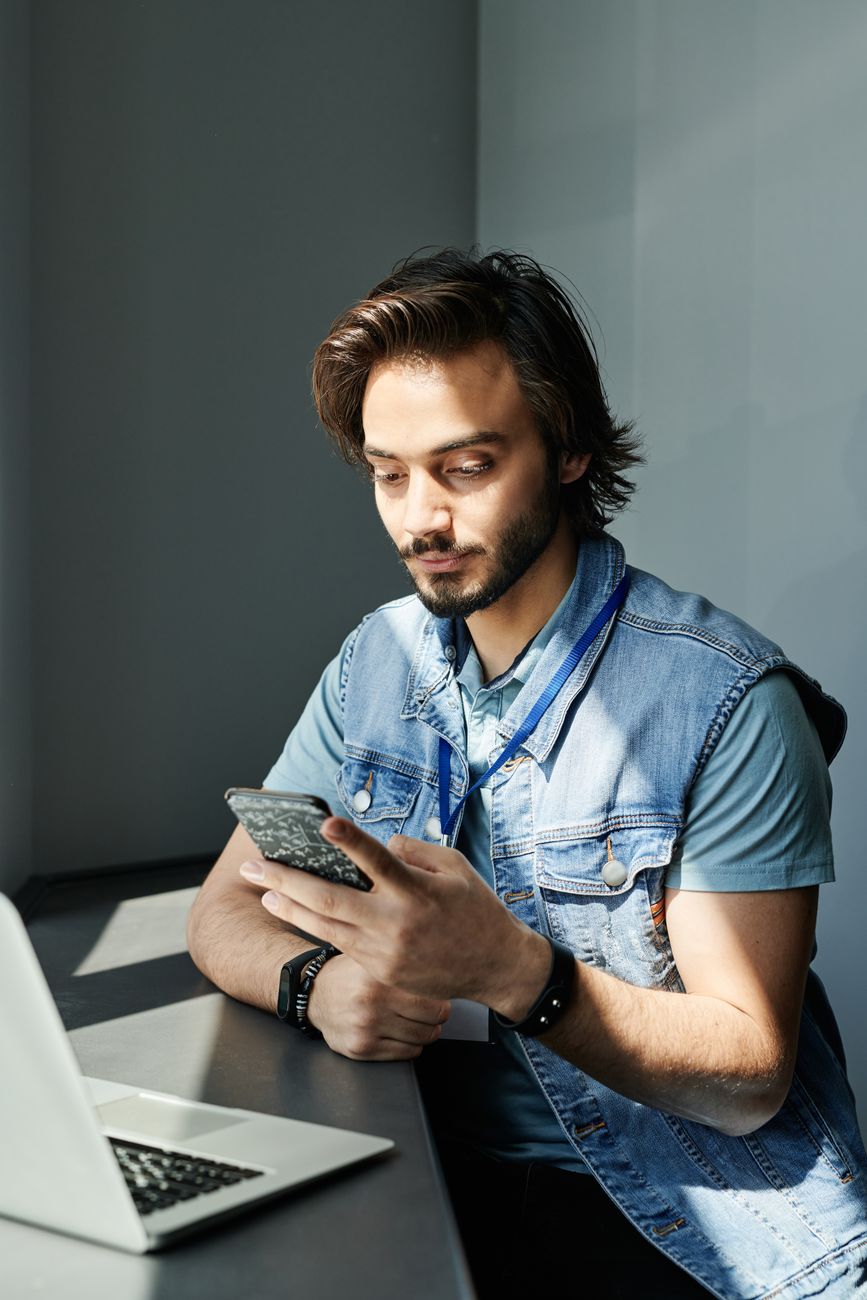 Profissional respondendo mensagens de clientes no celular em contexto de trabalho